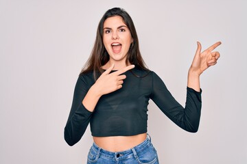 Young beautiful brunette woman wearing casual sweater and jeans standing over isolated background smiling and looking at the camera pointing with two hands and fingers to the side.