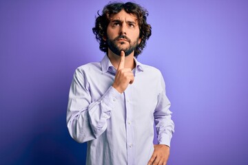 Young handsome business man with beard wearing shirt standing over purple background Thinking...