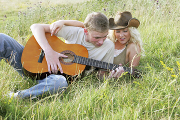 A guy playing a song on his guitar for his girlfriend