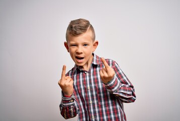 Young little caucasian kid with blue eyes wearing elegant shirt standing over isolated background Showing middle finger doing fuck you bad expression, provocation and rude attitude. Screaming excited