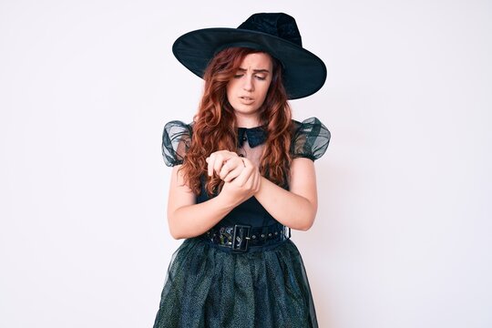 Young beautiful woman wearing witch halloween costume suffering pain on hands and fingers, arthritis inflammation