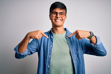 Young handsome man wearing casual shirt and glasses over isolated white background looking...