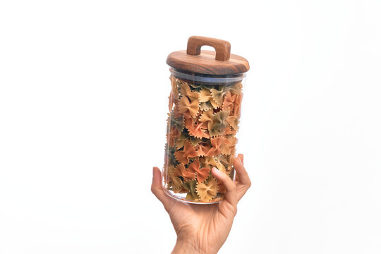 Glass jar full of dry italian vegetables pasta over isolated background