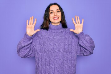 Young beautiful woman wearing casual turtleneck sweater standing over purple background showing and pointing up with fingers number ten while smiling confident and happy.