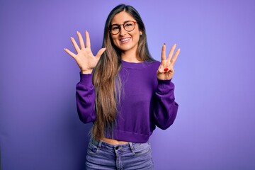 Young beautiful smart woman wearing glasses over purple isolated background showing and pointing up with fingers number eight while smiling confident and happy.