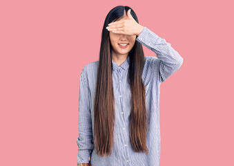 Young beautiful chinese woman wearing casual shirt smiling and laughing with hand on face covering eyes for surprise. blind concept.