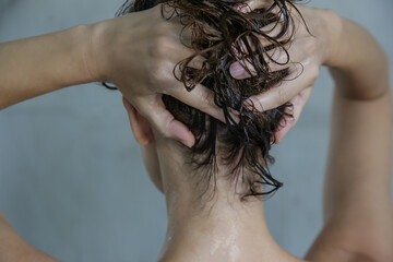 Hair shampooing and scalp massage. Back view of woman in the shower cabin.