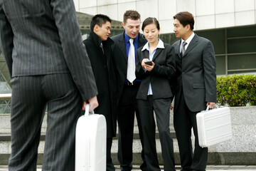 A woman teaching her friends how to use a palmtop