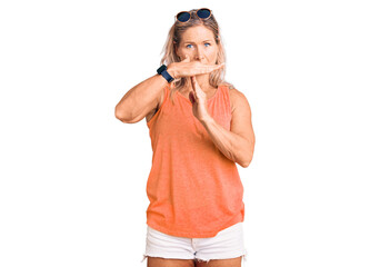 Middle age fit blonde woman wearing casual summer clothes and sunglasses doing time out gesture with hands, frustrated and serious face