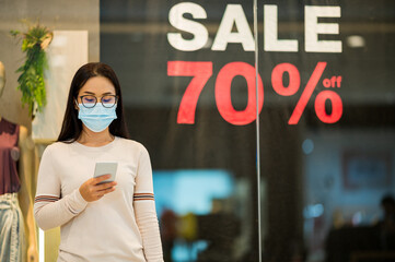 Shopping is a major pastime in Asian regions woman wearing face mask shopping in department store...