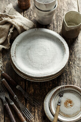 Empty ceramic tableware and old forks on a wooden table.