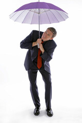Man in business suit holding an umbrella while checking the weather