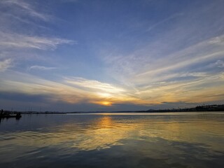 River horizon sunset landscape. Industrial pond in Yekaterinburg, Iset river in summer with sun and clouds reflection in water
