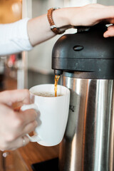 Woman Pouring Coffee Into Mug
