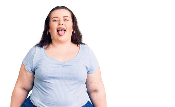 Young plus size woman wearing casual clothes sticking tongue out happy with funny expression. emotion concept.