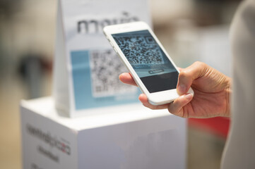 Asian woman And hold a mobile phone, scan the qr code for payment.New normal live social relaxation...