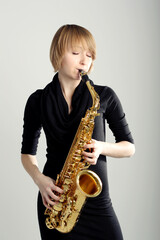 Naklejka premium Girl playing the alto saxophone. Saxophonist musician