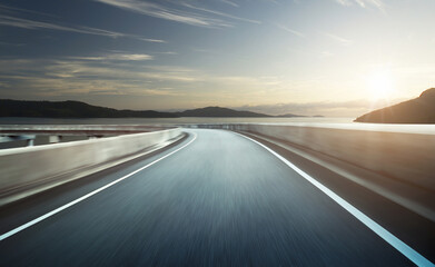 Highway and curve bridge overpass motion blur with seascape background during sunset.