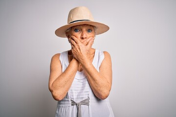 Senior beautiful grey-haired woman on vacation wearing casual summer dress and hat shocked covering mouth with hands for mistake. Secret concept.