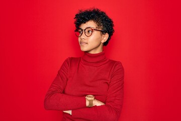Young beautiful african american afro woman wearing turtleneck sweater and glasses looking to the...
