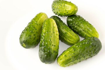 A few fresh green cucumbers on a light background. The concept of natural food. Selective focus.