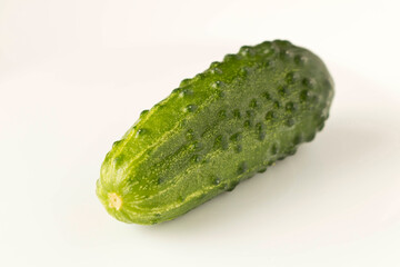 Fresh green cucumber on a light background. The concept of natural food. Selective focus.