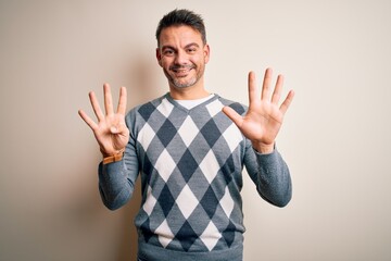 Young handsome man wearing casual sweater standing over isolated white background showing and...