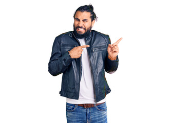 Young arab man wearing casual leather jacket pointing aside worried and nervous with both hands,...