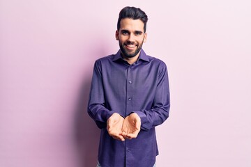 Young handsome man with beard wearing casual shirt smiling with hands palms together receiving or giving gesture. hold and protection