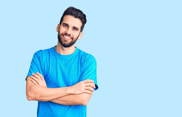 Fototapeta premium Young handsome man with beard wearing casual t-shirt happy face smiling with crossed arms looking at the camera. positive person.