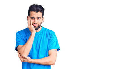 Fototapeta premium Young handsome man with beard wearing casual t-shirt thinking looking tired and bored with depression problems with crossed arms.
