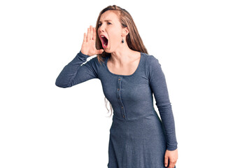 Young beautiful blonde woman wearing casual dress shouting and screaming loud to side with hand on mouth. communication concept.