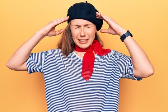 Young beautiful blonde woman wearing french fashion style with scarf and beret with hand on head, headache because stress. suffering migraine.