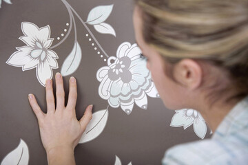 Obraz na płótnie Canvas Woman checking wallpaper's texture
