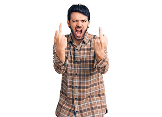 Naklejka premium Young hispanic man wearing casual clothes showing middle finger doing fuck you bad expression, provocation and rude attitude. screaming excited
