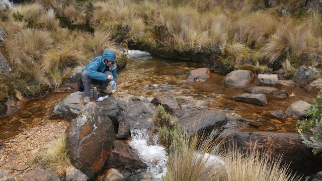 Refilling water bottle in the Andes mountains, santa cruz trek peru.