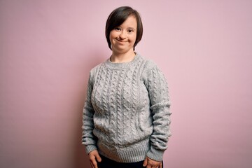 Young down syndrome woman wearing casual sweater over isolated background with a happy and cool smile on face. Lucky person.