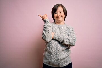 Young down syndrome woman wearing casual sweater over isolated background with a big smile on face,...