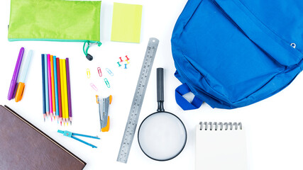 Blue backpack with surrounded by school supplies