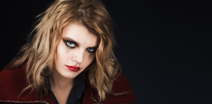 Halloween. Young girl in halloween stylized makeup on a dark background