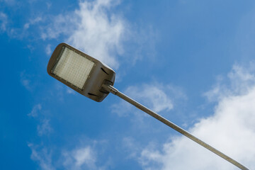 Street lantern on sky with white clouds background.A modern street LED lighting pole. 