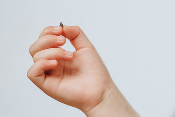 A small black chip holds a children's hand. Chipization of people after an epidemic coronavirus. 