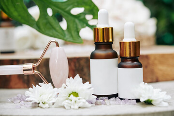 Rose quartz massage rollers and bottles with oils and serums for rejuvenating spa procedures