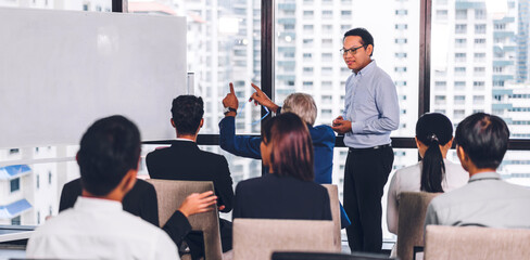Fototapeta na wymiar Businessman standing in front of group of people in consulting meeting conference seminar at hall or seminar room.presentation and coaching concept