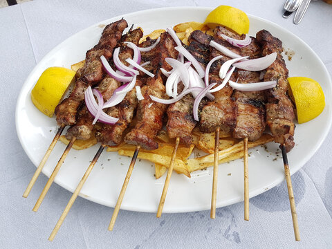 souvlakia greek tranditional food of meat onion lemon and potatoes in a plate