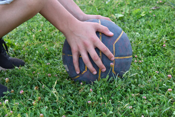 boy's hands on a basketball on the grass