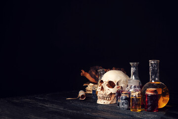 Potions and human skull on alchemist's table