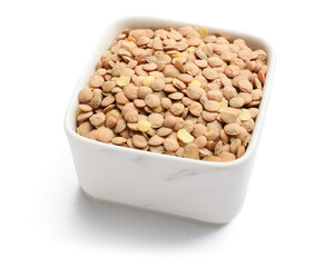 Raw lentils in bowl on white background