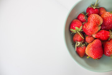  Juicy eco-friendly strawberries in a ceramic green plate on a white table mockup with copy space. Top view. Flat lay