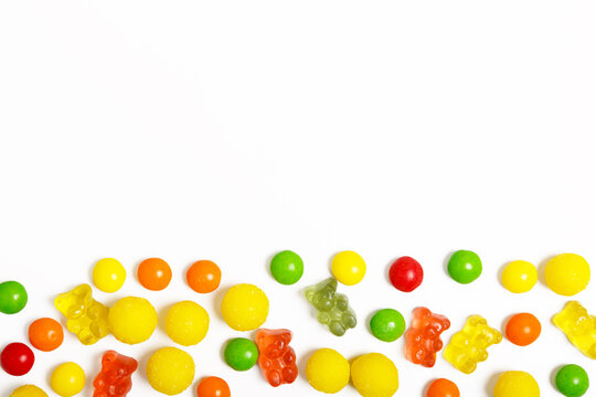 multicolored round candies and jelly bears on a white background. sweets store concept. Beautiful background for the designer. sweets concept for kids. flat lay, copy space.
